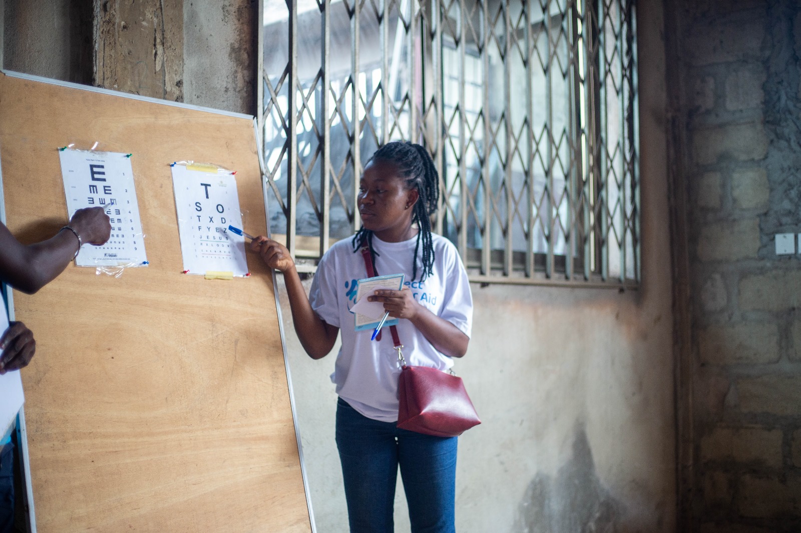 Volunteer pointing to eye chart